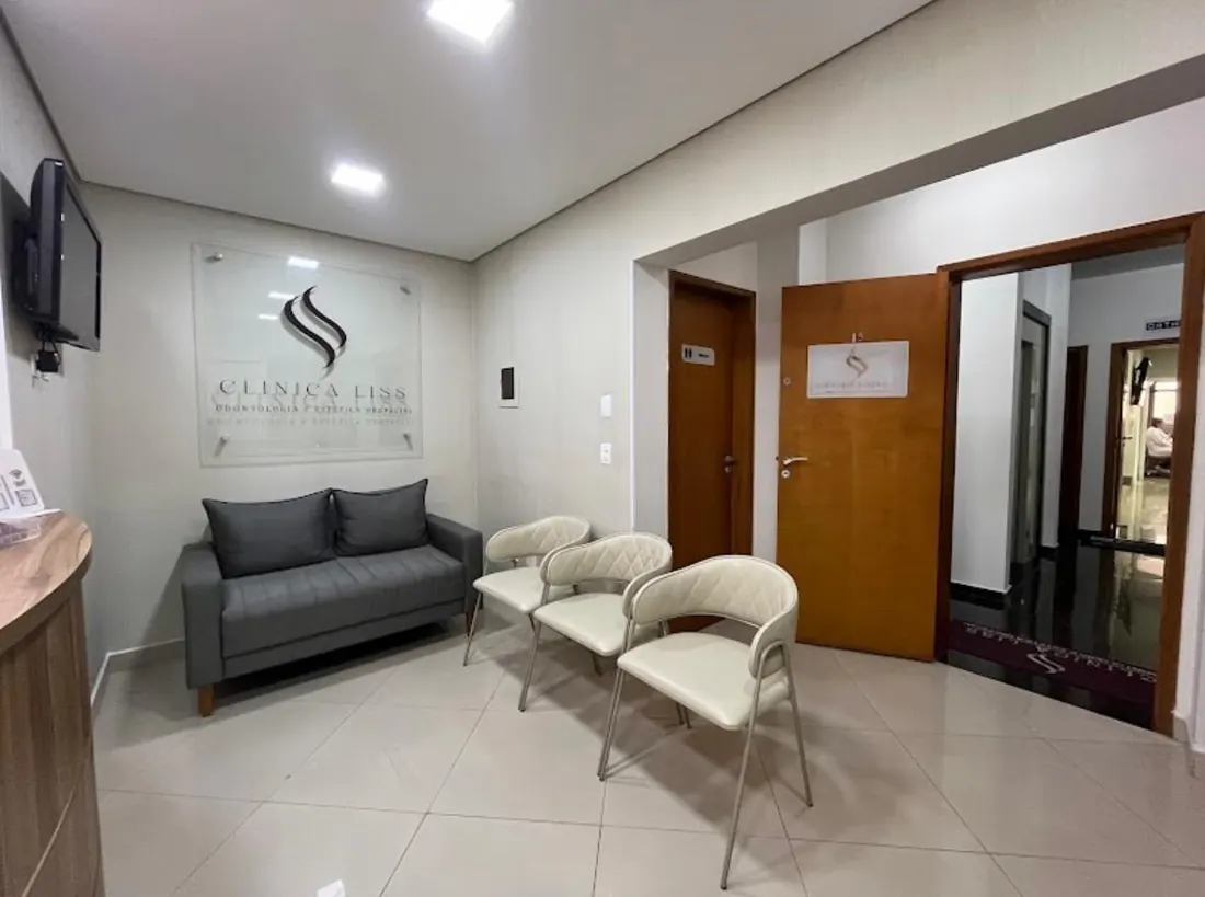 Recepção da Clínica Liss, com sofá, poltronas e a marca da clínica na parede